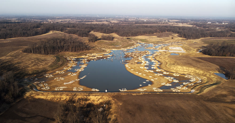 Lake about ½ filled, with lots of rock piles showing
