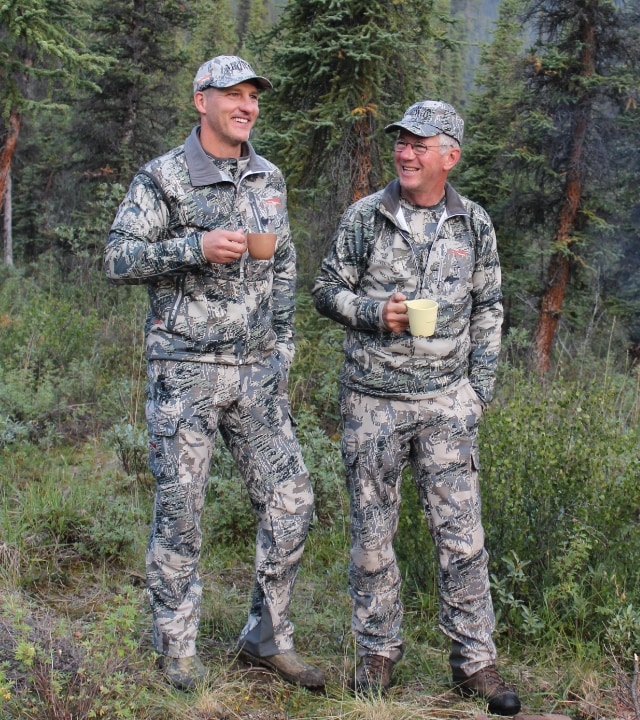 Two leaders of MidwayUSA standing smiling while holding coffee